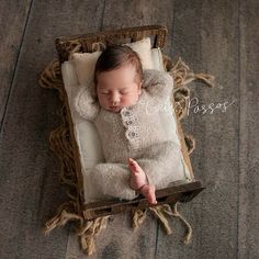 a baby is sleeping in a box on the floor