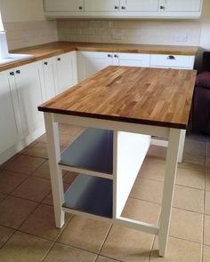 a kitchen with white cabinets and wooden counter tops