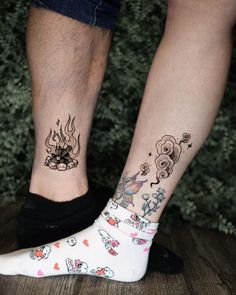 two people with tattoos on their legs standing next to each other, both wearing socks