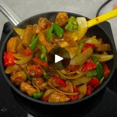 a pan filled with meat and vegetables on top of a stove next to a yellow spatula