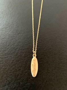 "Dainty gold tone surfboard necklace with engraved wave design, surfboard necklace, surfboard jewelry, surfboard pendant, surf board necklace, surfer necklace, surfer gifts Pendant measures 7/8\" L X 1/4\" W and is on an 18\" chain. ★ Want to see more?  Please visit my shop at: https://www.etsy.com/shop/DesignsByPeg" Surf Board Necklace, Surfer Boy Jewelry, Surfboard Jewelry, Surfer Gifts, Surfboard Necklace, Surf Necklace, Surfer Jewelry, Surf Yoga, Surfer Boy