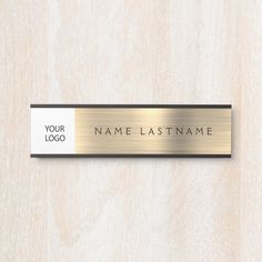 a metal name plate on a wooden surface