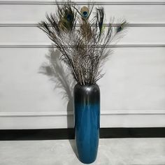 a blue vase with some feathers in it