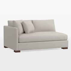 a white couch with two pillows on the back and one arm folded over it's head