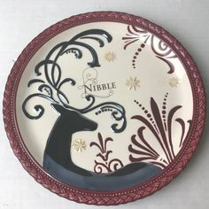 a white and red plate with a black deer on it's side that says nibble