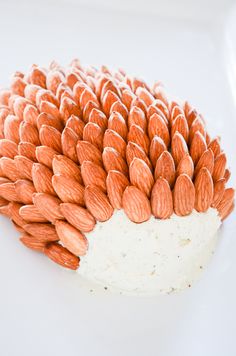 a white plate topped with a cake covered in orange and white frosted almonds