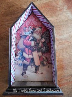 an origami christmas card in a house shaped like santa clause holding a sack of presents