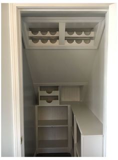 an empty pantry with shelves and drawers in the door way to another room that has white walls