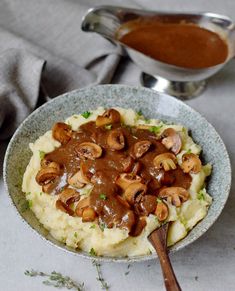 mashed potatoes with mushrooms and gravy in a bowl