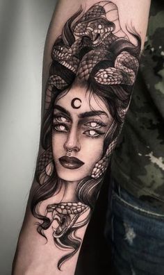 a woman's arm with a snake on it and her face painted in black ink