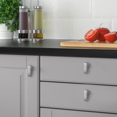 two tomatoes are sitting on a cutting board