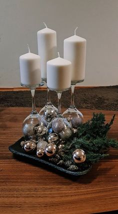 candles and ornaments sit on a tray with wine glasses