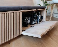 a wooden bench with bottles in it on the floor