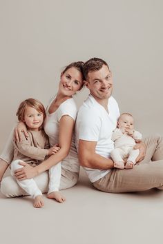 a man, woman and child are sitting on the floor with their arms around each other