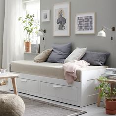 a white bed sitting in a bedroom next to a window