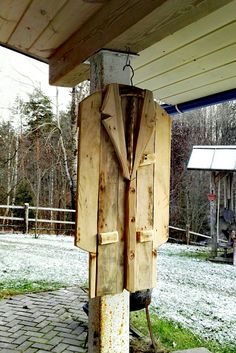 an old fashioned telephone on the side of a building in front of a snow covered yard