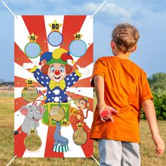 a young boy standing in front of a carnival poster with clowns and elephants on it