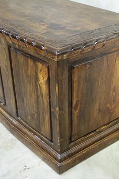 an old wooden box with metal chains on the top and bottom, sitting on a white surface