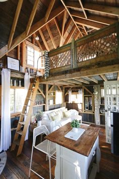 a living room and dining area in a wooden structure with stairs leading up to the second floor