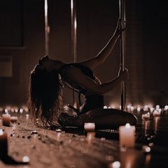 a woman sitting on the floor in front of candles with her legs spread out and hands behind her head