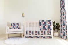 a baby's room with a crib, chair and rug