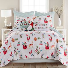 a white bed with christmas themed comforter and pillows