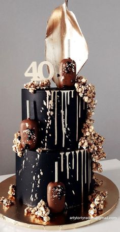 a three tiered cake with chocolate covered candies on top