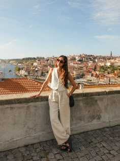 a woman standing on top of a stone wall