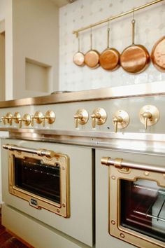 an old fashioned stove with brass knobs and oven doors on the wall behind it