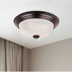 a light that is on above a bed in a room with curtained walls and curtains