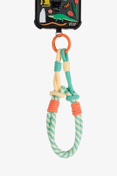 an animal toy hanging from a hook on a white wall with a green and orange rope