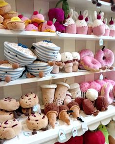 many stuffed animals are on shelves in a store, including donuts and other items