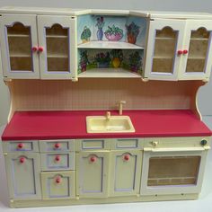 a doll house kitchen with sink and cupboards