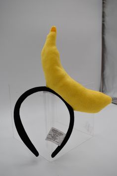 a banana headband sitting on top of a clear display case with a black rubber band