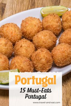 some fried food on a white plate with lime wedges