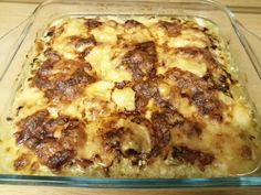 a casserole dish with meat and cheese in it on a wooden table top