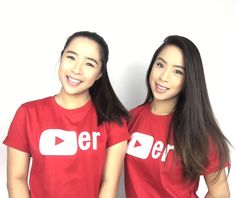 two women wearing red shirts with white letters on them