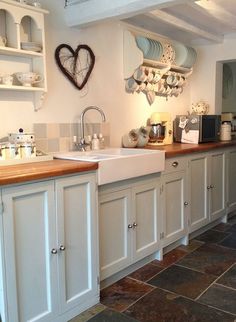 a kitchen filled with lots of white cupboards and counter top next to a sink