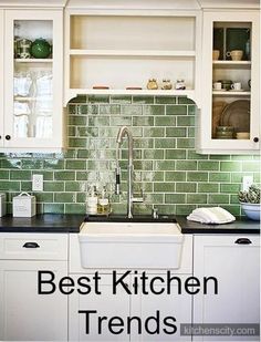 a kitchen with white cabinets and green tile backsplash