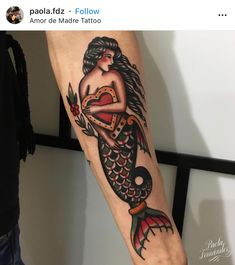 a woman's arm with a tattoo on it that has an image of a mermaid