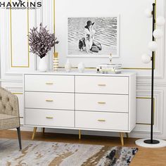 a white dresser sitting next to a chair in a living room