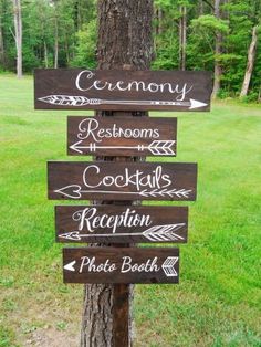 a wooden sign that says ceremony, restrooms, reception and photo booth on the side of a tree