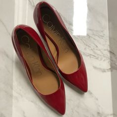 Size: 7.5 Color: Crimson Red Silver Detailing On Back, Tan Sole And Lining. “The Calvin Klein Gayle Pumps Are A Staple For Any Wardrobe. The Signature Pointy Toed Pump, Features A Mid-Height Stiletto Heel And A Metallic Brand Plate On The Back. Founded In New York In 1968, Calvin Klein Elevates Everyday Essentials To Globally Iconic Status.” Heel Height- 3.27" Shoe Width- Medium Pull On Or Slip On Closure Faux Leather Upper; Manmade Lining; Rubber Sole Pointy Toe Leather And Faux Leather Calvin Klein Round Toe Heels With Branded Heel Counter, Classic Calvin Klein Round Toe Heels, Red Court Shoes With Padded Heel, Calvin Klein Heels With Round Toe And Branded Insole, Calvin Klein Closed Toe Heels With Branded Insole, Classic Red Heels, Medium Width, Spring Red Court Shoes With Branded Heel, Red Court Shoes With Reinforced Heel And Medium Width, Red Court Shoes For Spring Workwear