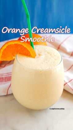 orange creamsice smoothie in a glass with an orange slice on the rim