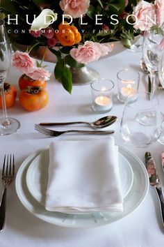 the table is set with silverware, flowers and candles for an elegant wedding reception