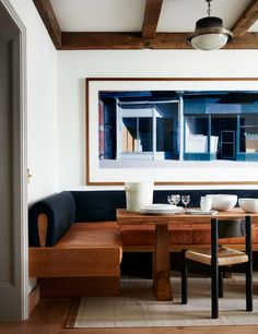 a dining room table with two chairs and a painting hanging on the wall above it