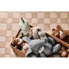 several stuffed animals are in a basket on the floor