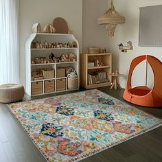 a child's playroom with toys, bookshelves and rugs on the floor