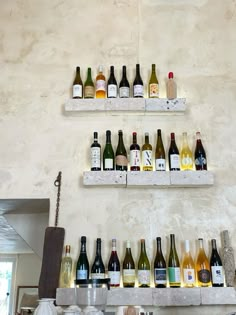 several bottles of wine are lined up on the wall