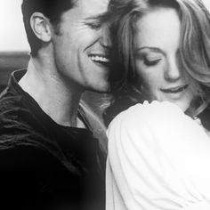 a black and white photo of a man and woman hugging each other with their eyes closed